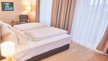 A hotel room with a bed, a chair, a lamp, and a painting on the wall.