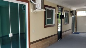 A hallway with a sliding glass door, a window with a view, and a wall-mounted air conditioning unit. - Praia do Foguete Style (Cabo Frio)