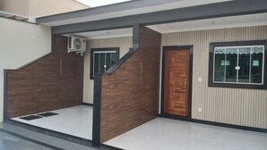 A modern house with a wooden exterior, a tiled entrance, and a window with a decorative frame. - Praia do Foguete Style (Cabo Frio)
