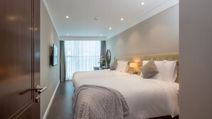 Une chambre d’hôtel avec un grand lit, une télévision et une fenêtre avec des rideaux.
