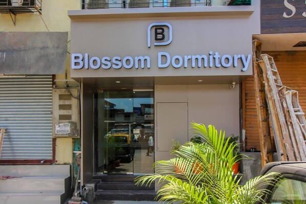 Exterior del dormitorio Blossom, con una entrada visible y un cartel.
