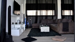 Una sala de estar moderna con un sofá modular, una mesa de centro y un televisor de pantalla plana montado en la pared.