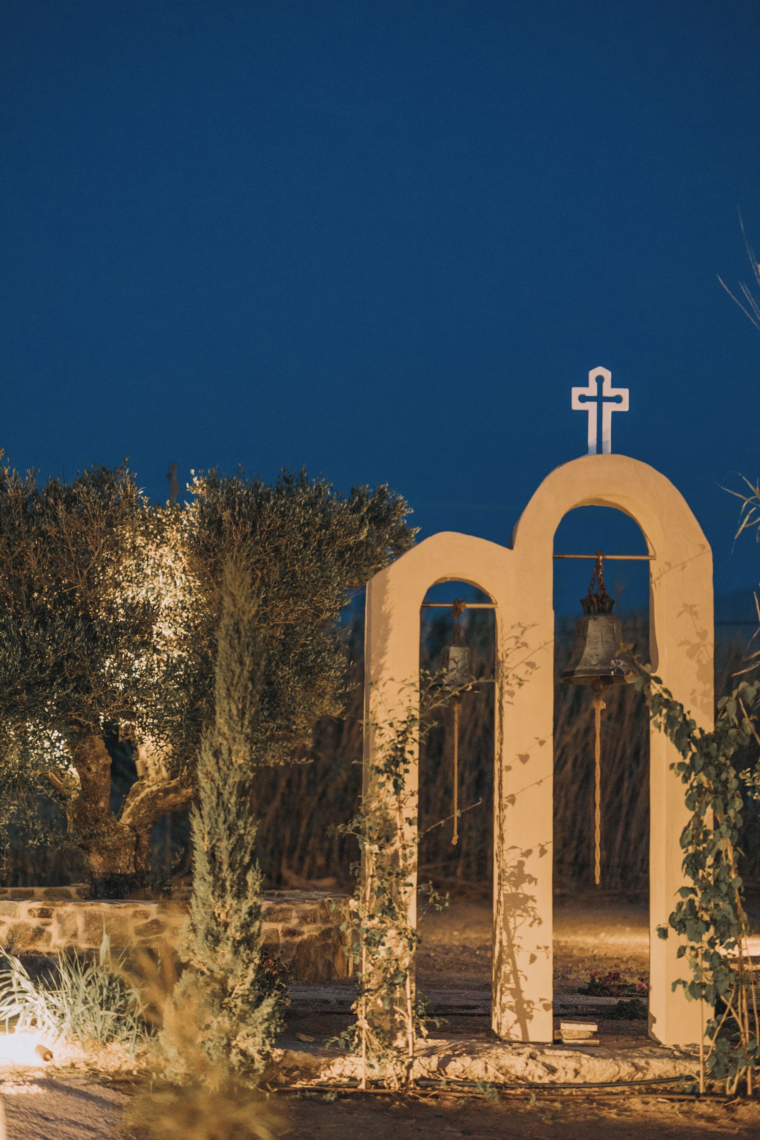 A church entrance with a bell tower and a cross.