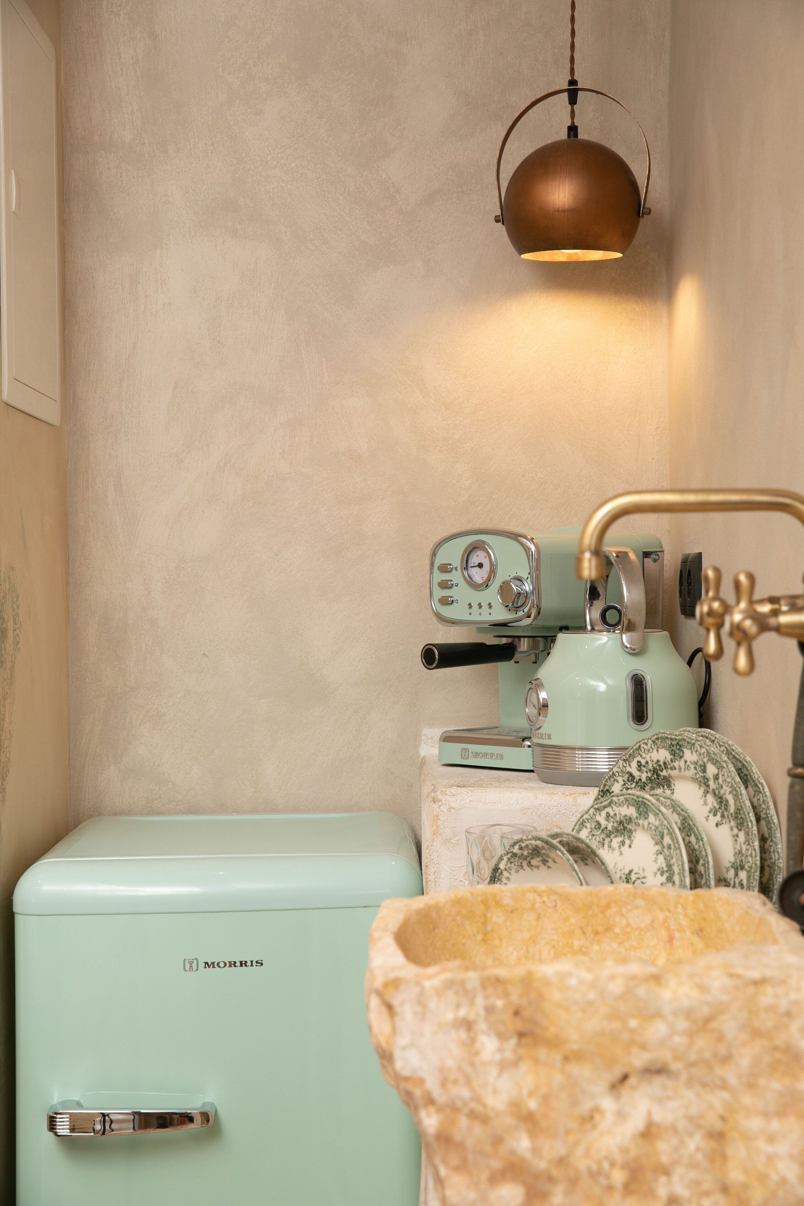 A vintage Morris refrigerator, a retro espresso machine, and a stone mortar.