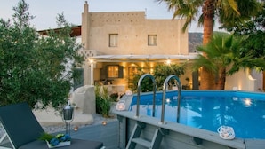 A pool area with a lounge chair, a ladder, and a small fountain. - Archetypo (Naxos)