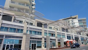Un edificio moderno a più piani con balconi, ampie finestre e una caratteristica architettonica curva distintiva.