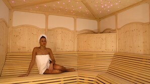 Un sauna en bois, doté de bancs et d’un plafond agrément é de petites lumières.