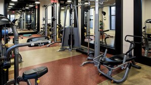 Une salle de sport équipée de divers appareils d’entraînement, notamment des machines à poids et des poids libres.