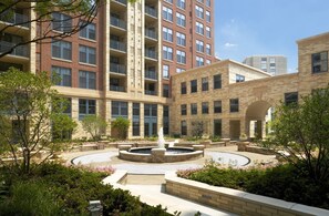 A courtyard with a central fountain, surrounded by brick buildings with multiple floors and balconies. - Stay With Kay Pentagon City (Arlington)