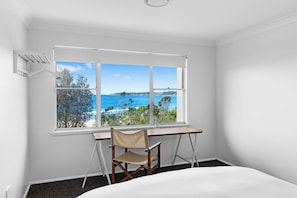 A room with a large window offering a view of the sea and distant land. - Beach House - footsteps from the sand (Mollymook Beach)