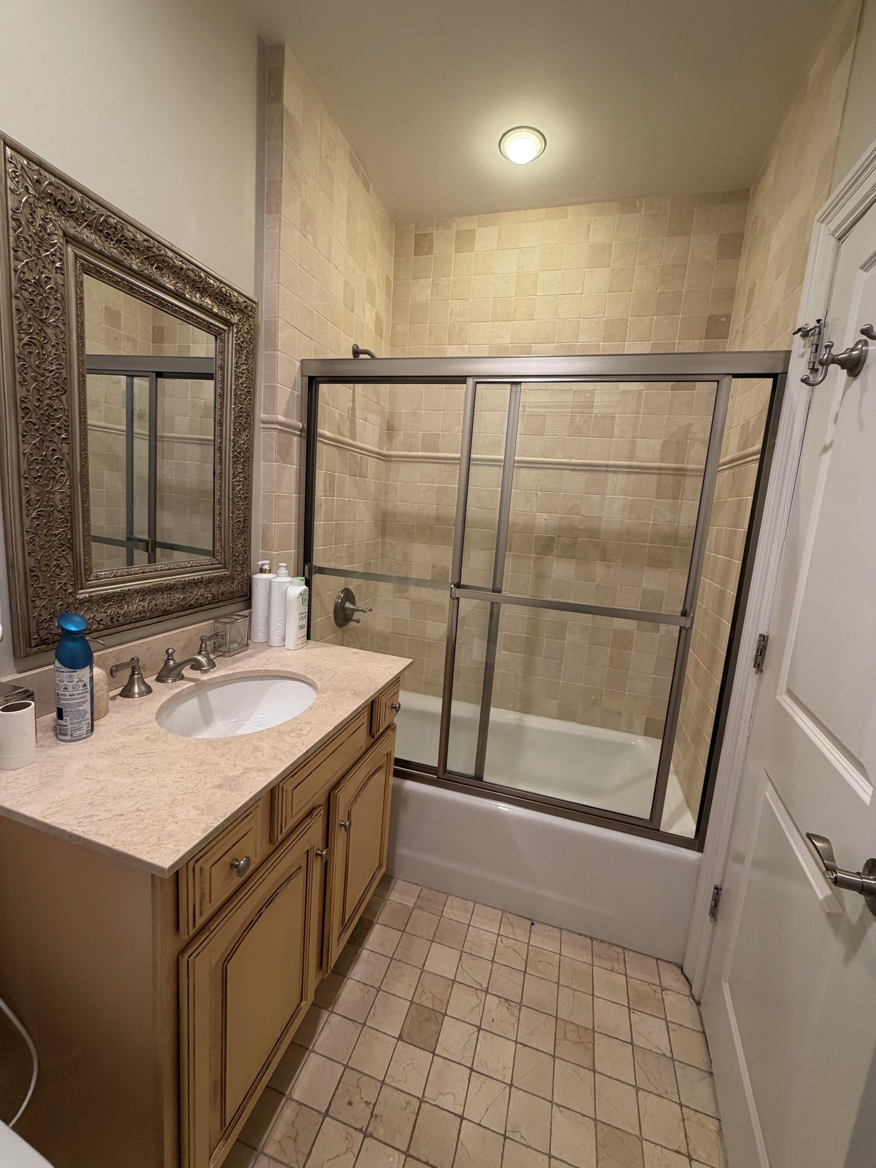 A bathroom with a sink, mirror, shower enclosure, and bathtub.