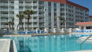 A hotel with a swimming pool, multiple balconies, and palm trees. - El Matador 424 by Alicia Hollis Rentals FREE TICKETS! $300/Day (Fort Walton Beach)