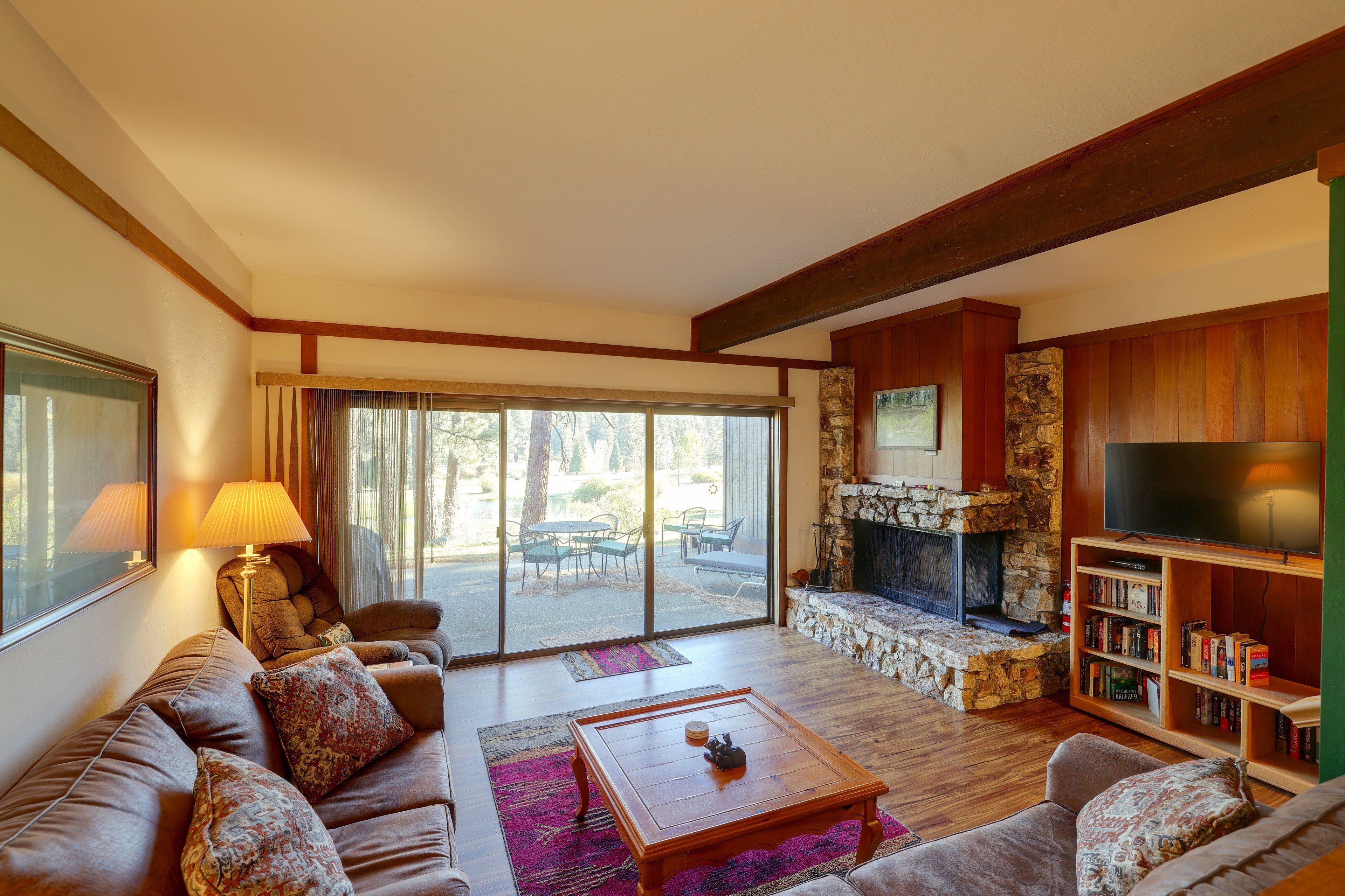 A living room with a sofa, coffee table, fireplace, and a bookshelf.