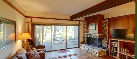 A living room with a sofa, coffee table, fireplace, and a bookshelf.