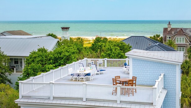 A deck with outdoor furniture overlooking a beach and ocean. - 3800 Cameron Boulevard| AvantStay | Pool, Ocean Views, Deck (Isle of Palms)