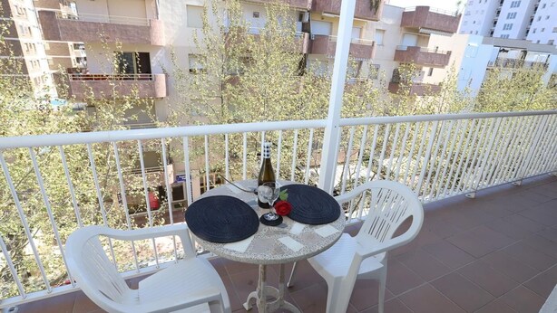 A balcony with two white plastic chairs and a small round table, a bottle, and a glass. - 161 - COSTA AZUL LUXE..Spacious and central apartment with wonderful views (SALOU)