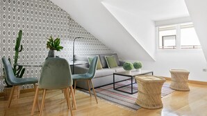 Eine moderne Loftswohnung mit hohen Decken, einem grauen Sofa, zwei Sesseln, einem Couchtisch und einer Wand mit Muster.