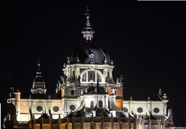 Ein großes, historisches Gebäude mit einer markanten Kuppel und mehreren Türmen, beleuchtet bei Nacht.