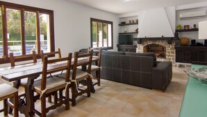 A spacious living area with a dining table, chairs, a sofa, and a fireplace. - Villa Comes - Beautiful villa with private pool 50 metres from the beach (Port d'Alcúdia)