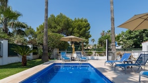 A swimming pool with blue tiles, surrounded by palm trees and a clear sky. - Villa Comes - Beautiful villa with private pool 50 metres from the beach (Port d'Alcúdia)