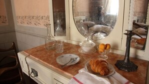 Un escriptori de desembre amb un croissant, un plat, un got i un espelma.