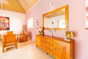 Ein Zimmer mit einem Holzschrank, einem großen Spiegel und einem Gemälde an der Wand.