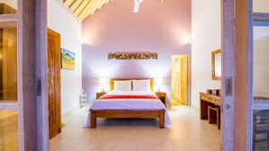 A bedroom with a wooden bed, a nightstand, a desk, and a chair. - Istana Willy (Ungasan)