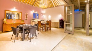 A spacious dining area with a high ceiling and a large window. - Istana Willy (Ungasan)