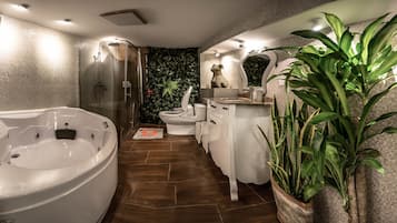 Une salle de bain moderne avec une grande baignoire, une douche, des toilettes et un lavabo.