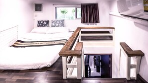 A bedroom with a bed, a wooden bench, and a small table.