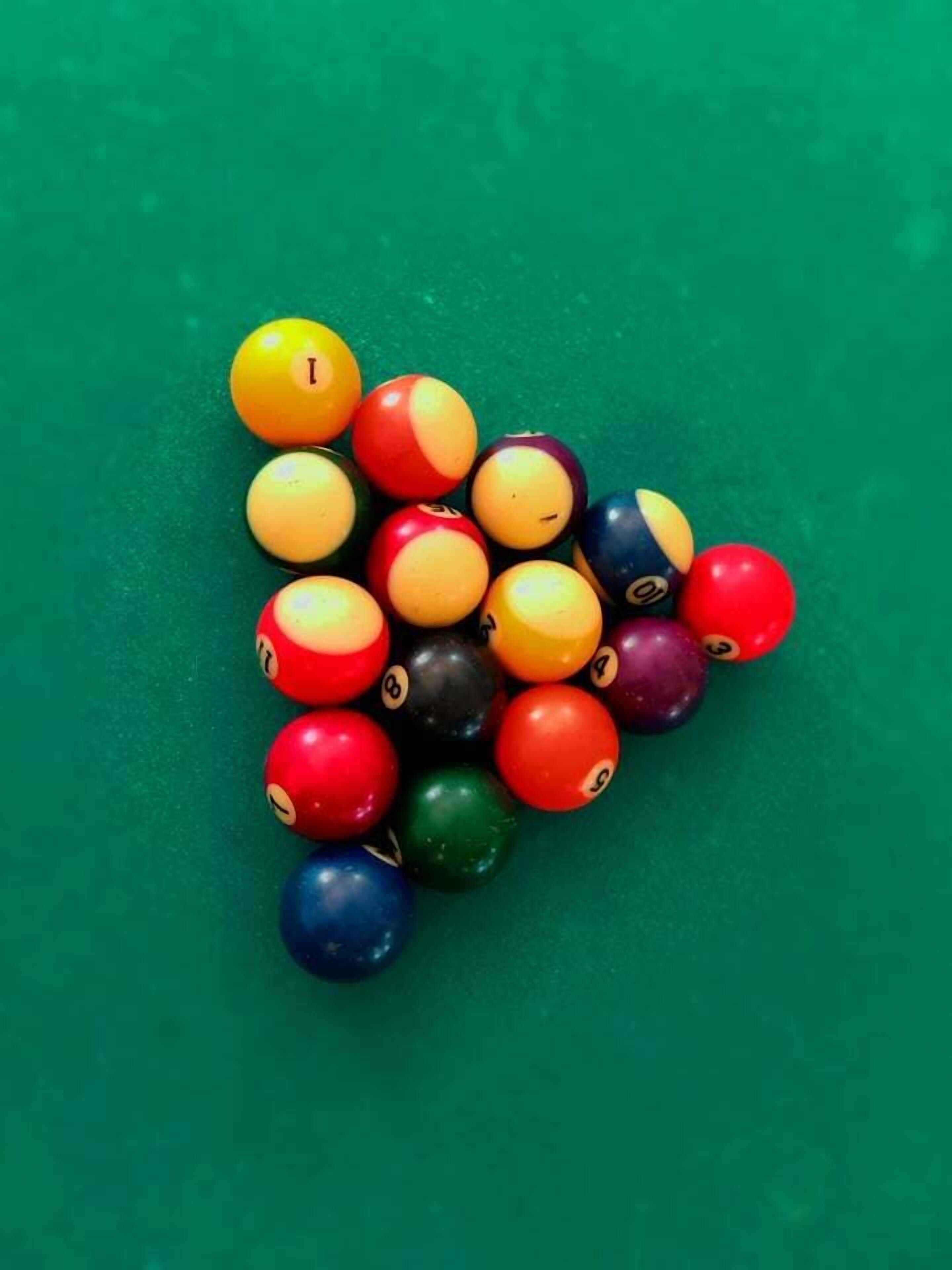 Un ensemble de billes de billard disposées sur une surface verte.