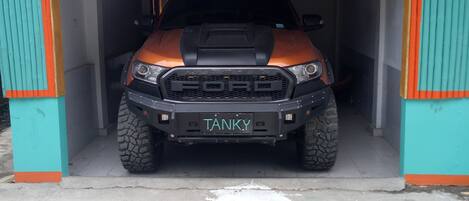 Un vehículo estacionado dentro de un garaje con detalles naranja y verde azulado.