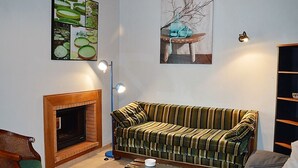 A living room with a striped sofa, a fireplace, a coffee table, and wall art.