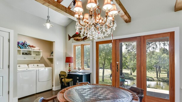Une cuisine spacieuse avec une grande table en bois, des appareils électroménagers intégrés et une vue sur l’extérieur.