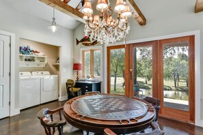 A spacious kitchen with a large wooden table, built-in appliances, and a view of the outdoors. - WATERFRONT CABIN Lake LBJ Cove, Fish/Float!, Fenced Yard PETS OK, Panoramic View (Burnet)