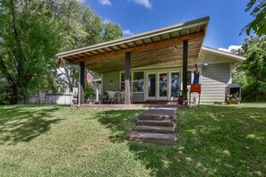 A house with a covered porch, a front door, and a small front yard.
