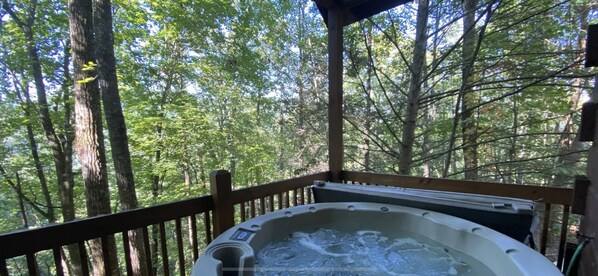 A hot tub on a wooden deck surrounded by a forest. - Winter Special in the quiet woods (Sevier County)