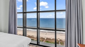 Une chambre avec une grande fenêtre donnant sur une plage.