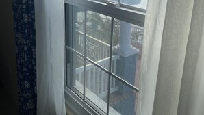 A window with a view of a cityscape and a body of water.