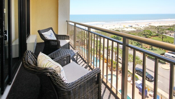 A balcony with wicker furniture and a view of the beach and ocean. - Beautiful 1Bd/1Ba Condo in Beachside Resort on The Golden Mile (Myrtle Beach)