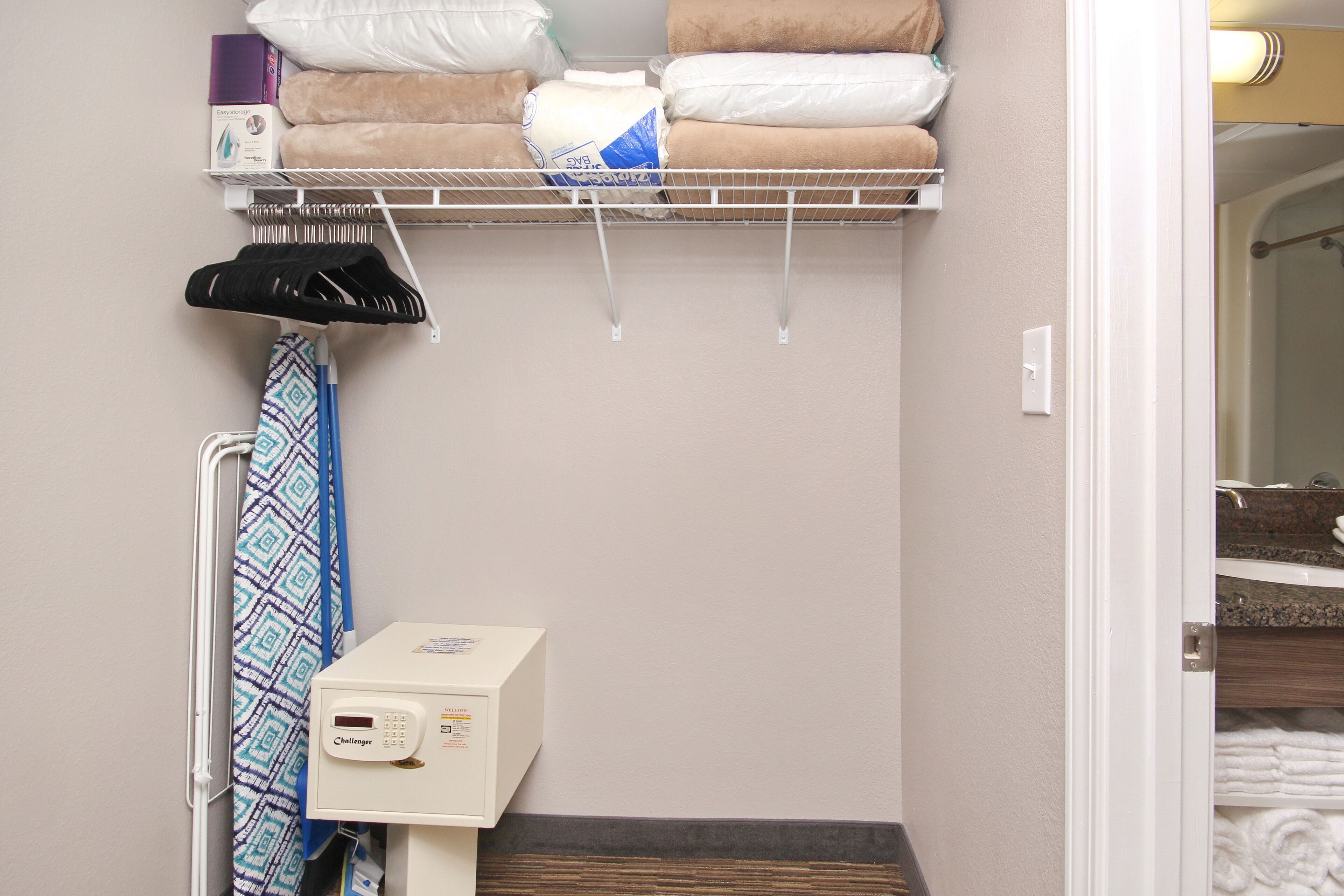 A bathroom with a towel rack, a hand dryer, a box of tissues, and a towel dispenser.