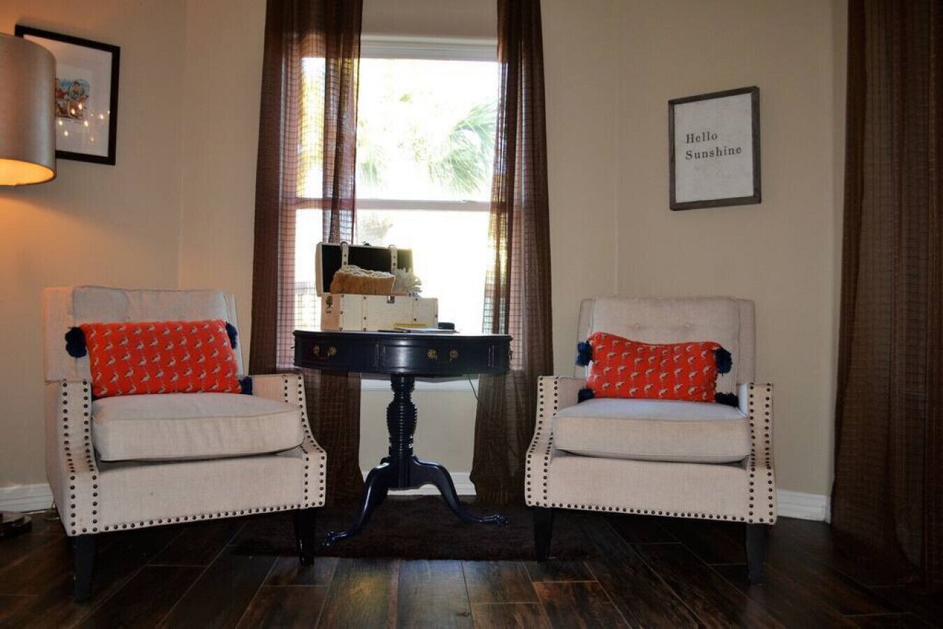 A room with two armchairs, a small table, and a window with curtains.