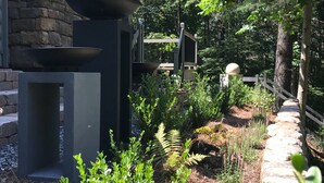 Ein Steinhaus mit Metallkonstruktion und einem Kiesweg.