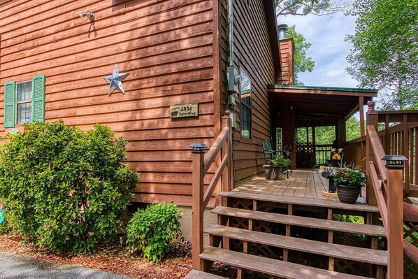 A wooden building with a porch, green shutters, and a star decoration.