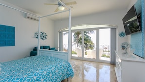 A bedroom with a bed, a ceiling fan, a large window, and a view of palm trees. - Views, Views, Views!! (Puerto Morelos)