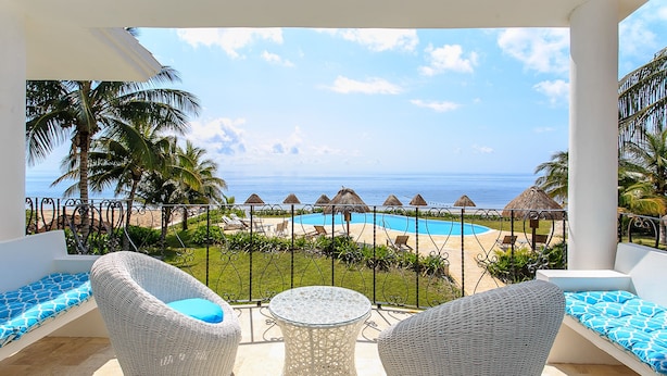 A balcony with wicker furniture, a pool, and a view of the beach and ocean. - Views, Views, Views!! (Puerto Morelos)