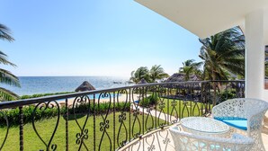 A balcony with a view of the sea, white wicker furniture, and a thatched-roof structure. - Views, Views, Views!! (Puerto Morelos)