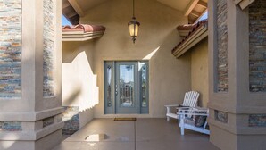 Un espacio al aire libre cubierto con una puerta, una silla y una mesa.