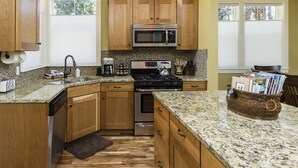 A kitchen with wooden cabinets, granite countertops, stainless steel appliances, and a window providing natural light. - Amazing West Side * 2 King Suites * Walk Everywhere  * 8 Person Hot Tub (Bend)