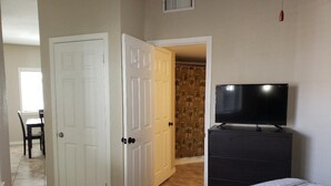 Une chambre à coucher avec un lit, une commode et un téléviseur.